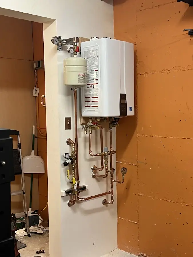Plumbing technician inspecting water heater connections in Griffith